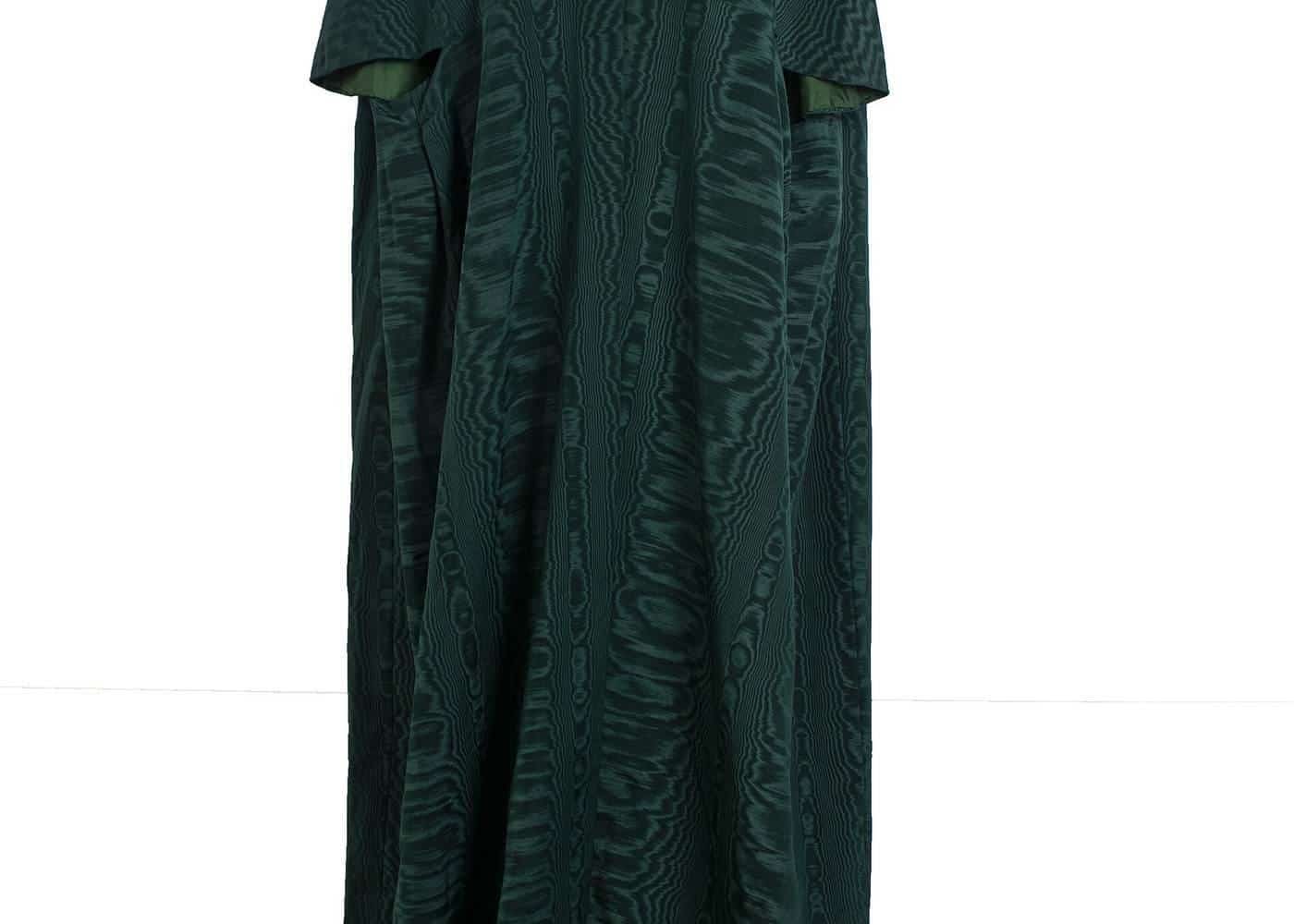 A full-length green kaftan dress displayed on a stand